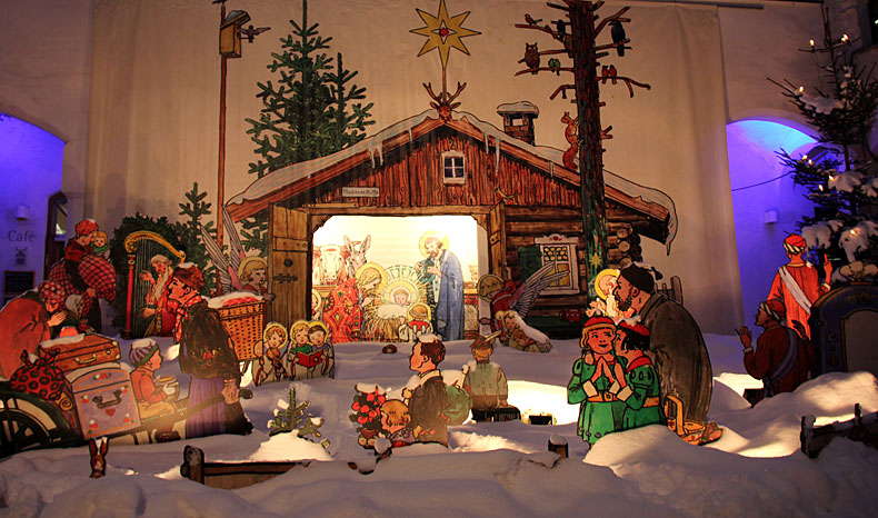 schneebedeckte Krippe mit lebensgroßen Figuren des Malers Madlener im Innenhof des Antonierhauses