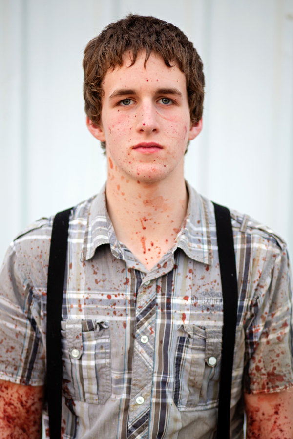 portraitaufnahme eines jungen Mannes, der mit Blut bespritzt ist