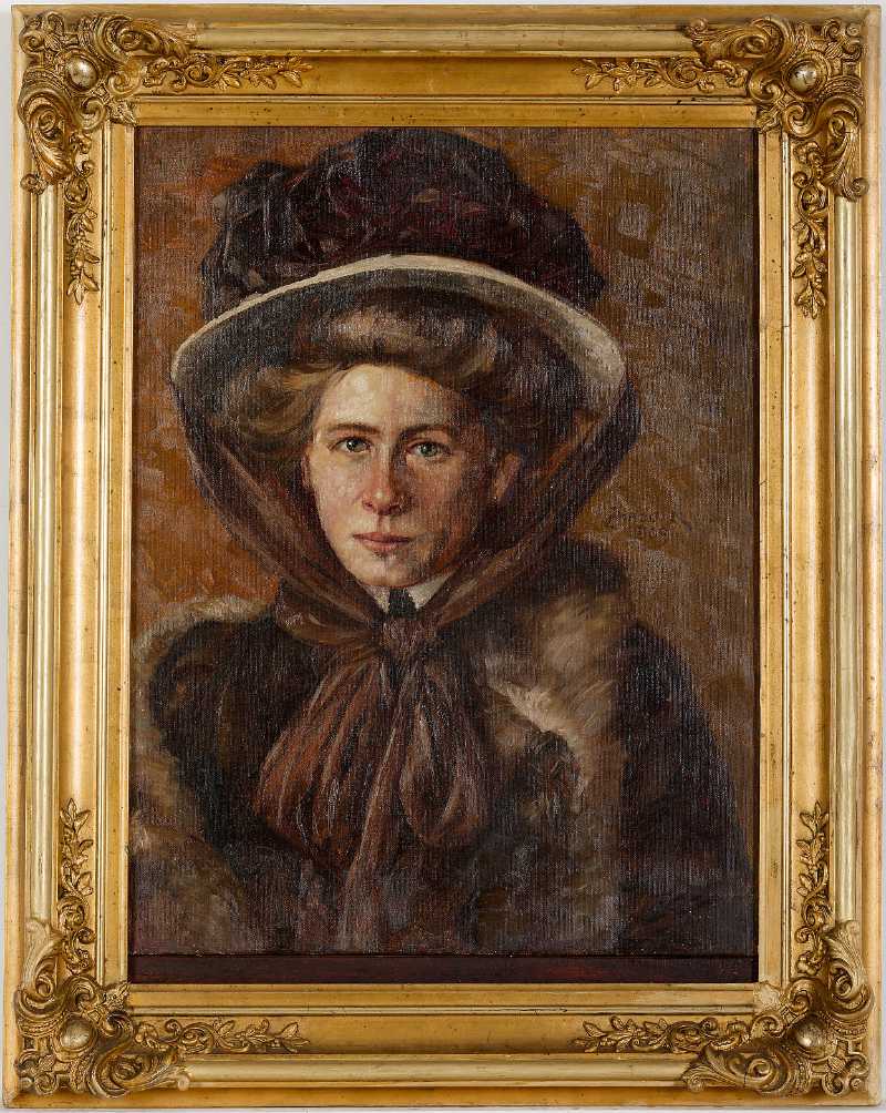 Das Prtrait einer Frau mit einem Pelzmantel und einem  Hut, der mit einer riesigen Schleife gehalten wird