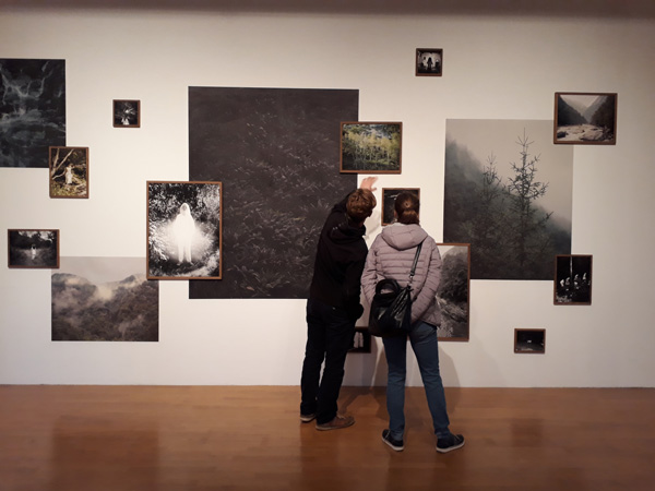 Besucher vor einer Wand mit Bildern