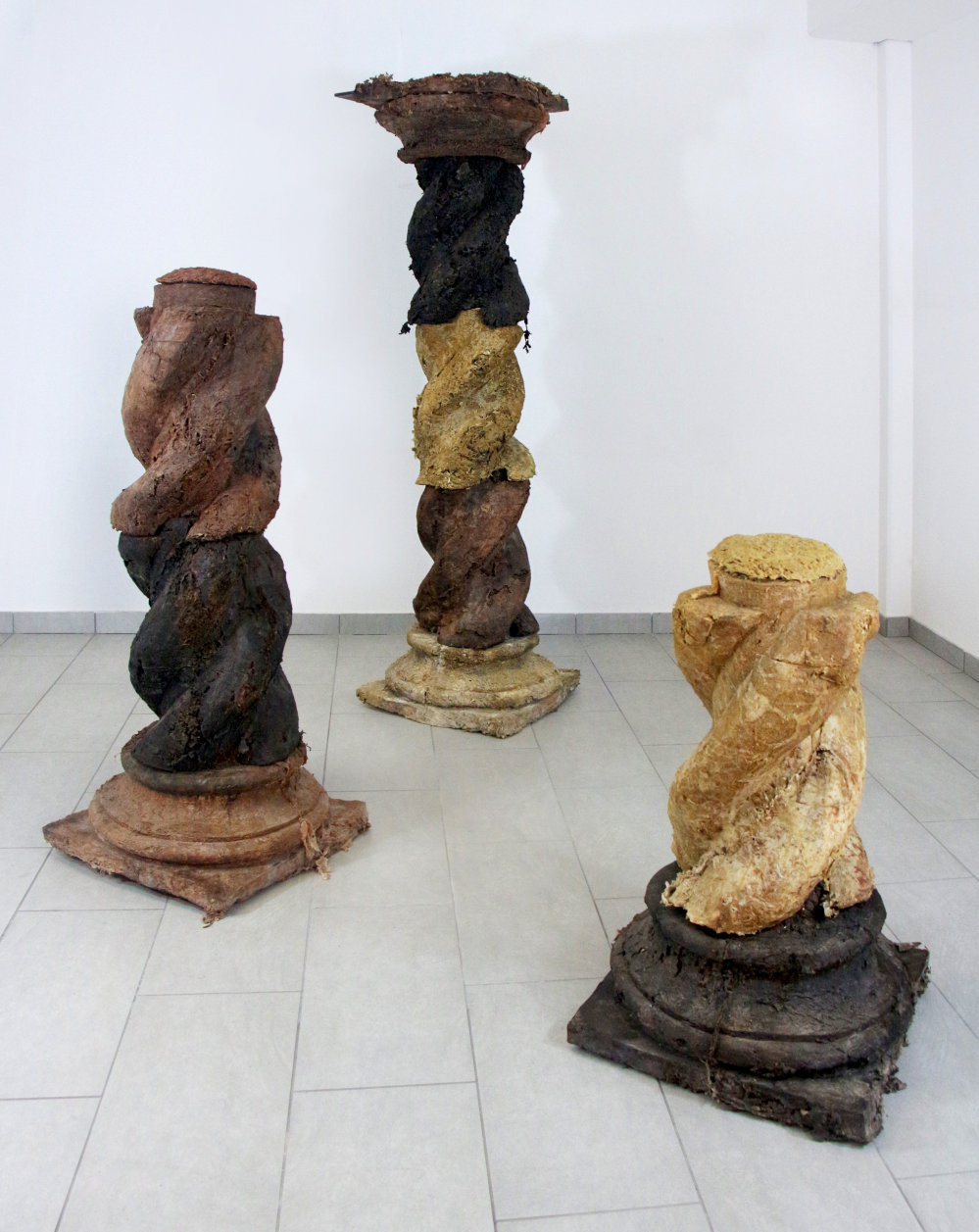 gewundene Säulen-Stümpfe aus organischen Materialien gepresst stehen auf dem Boden