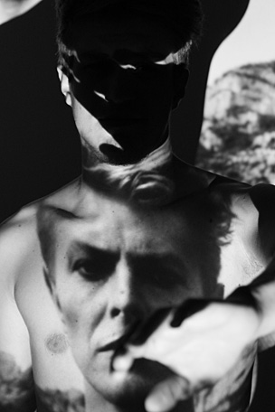 das Gesicht von David Bowie ist auf einen nachten Oberkörper projeziert