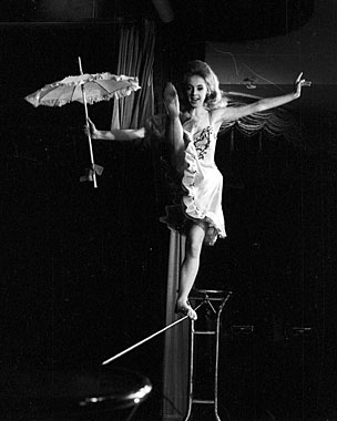 Schwarzweissfotografie: Frau balanciert mit Schirm auf einem Seil
